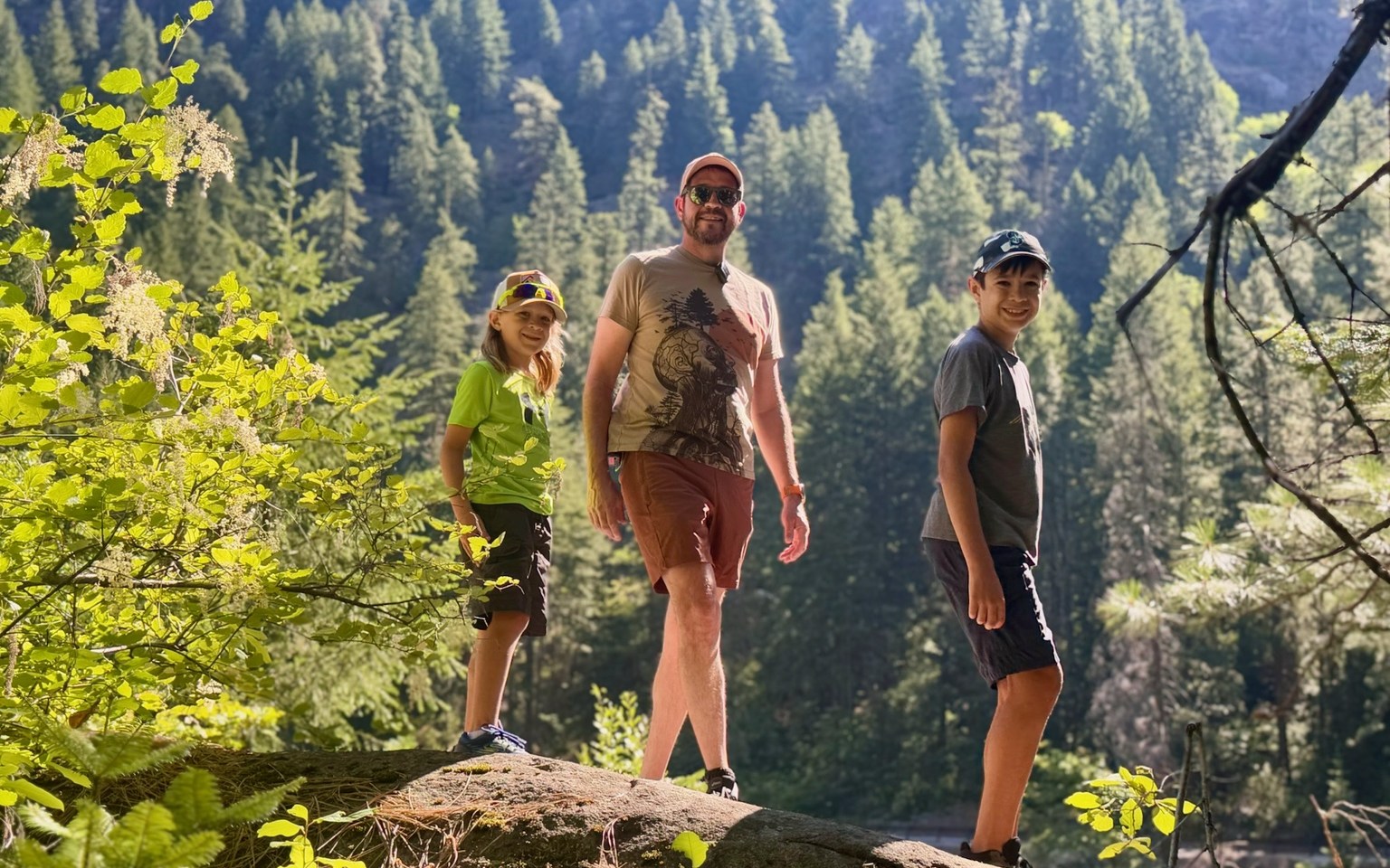Parent and two children standing together on a mountain trail