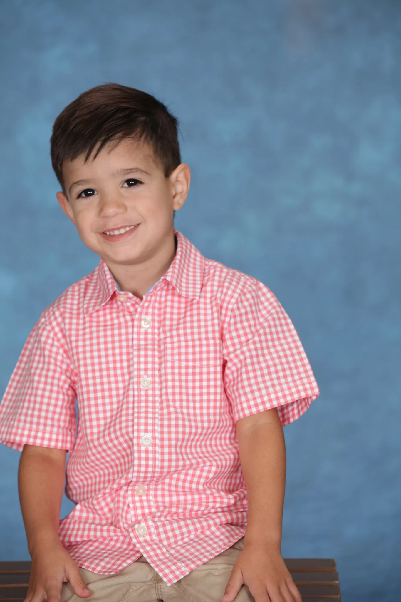 Rhys Stone in a daycare portrait against a blue studio backdrop