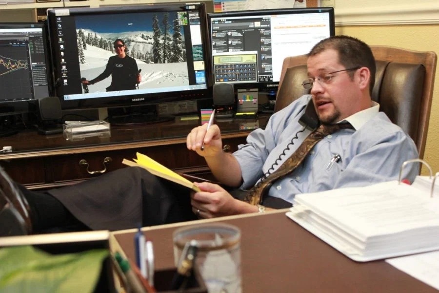 Randall Stone working at his desk with financial tools and market screens