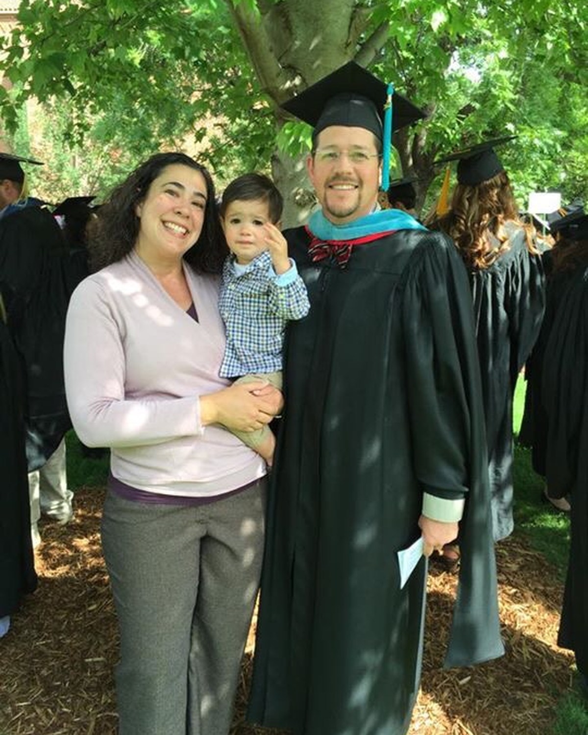 Randall Stone in academic regalia with family at his 2015 Master of Public Administration graduation and hooding ceremony
