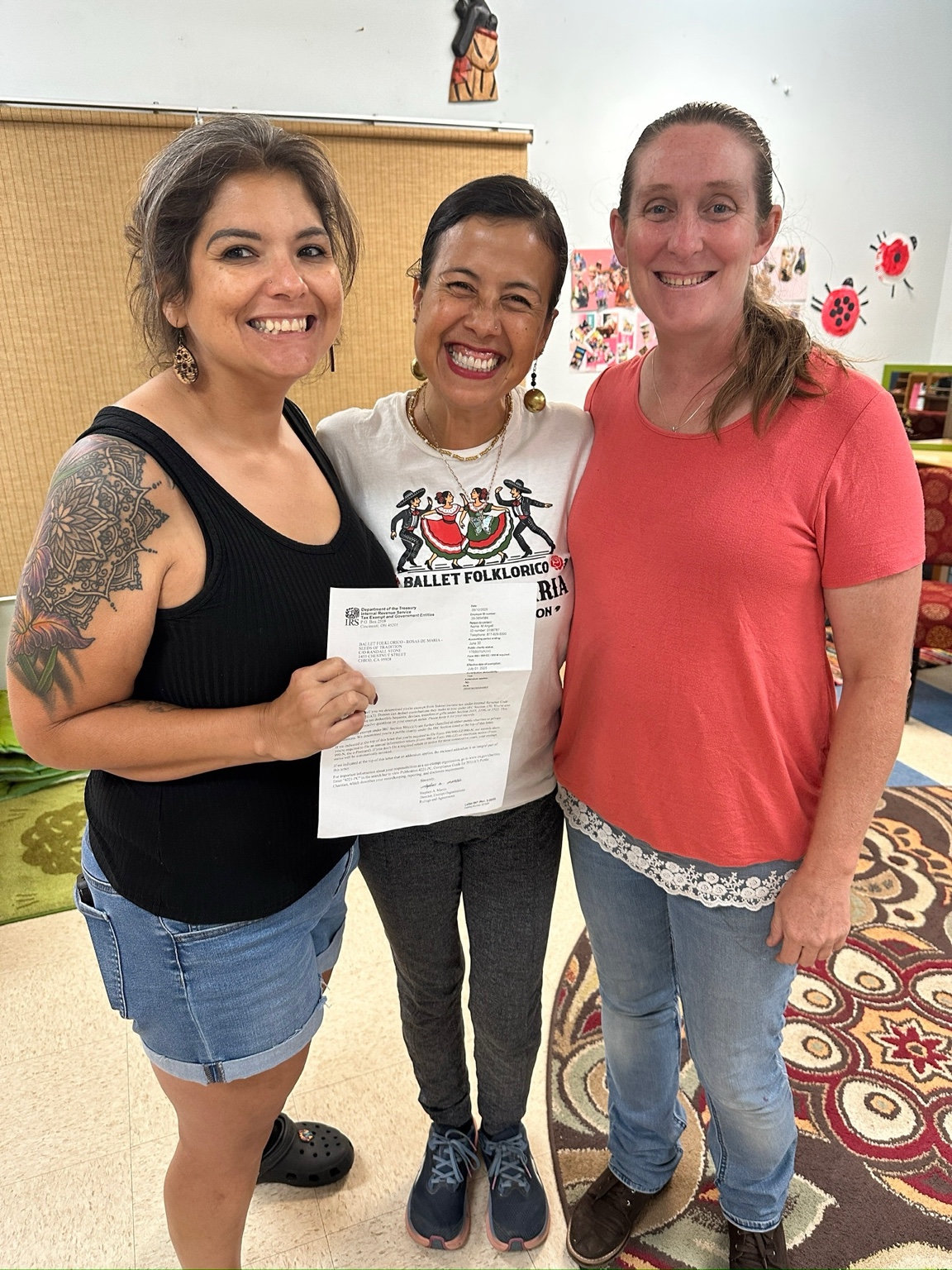 Latoyia Gonzalez, Maria Trenda and Joyce Becker holding the Rosas de María IRS 501(c)(3) determination letter at the May 2025 Board meeting